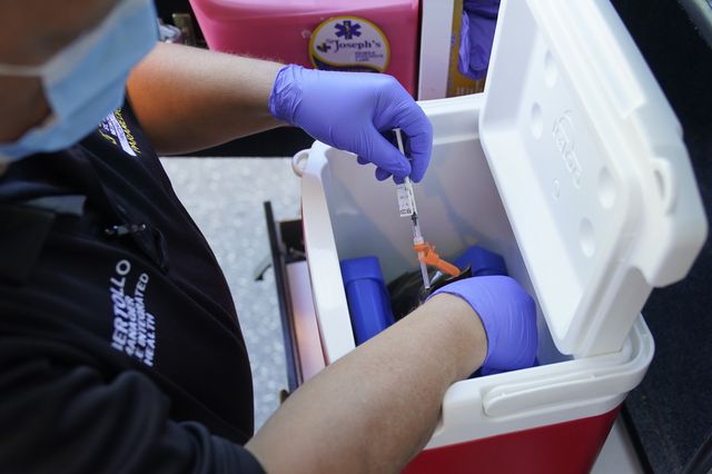 Paramedic Bob Bertollo retrieves a dose of the COVID-19 vaccine for a home-bound patient in Paterson, New Jersey. The Mobile Integrated Healthcare unit of St. Joseph's Health is delivering up to 12 doses a day of COVID-19 vaccines, twice a week, primarily to home-bound seniors, May 12th, 2021
